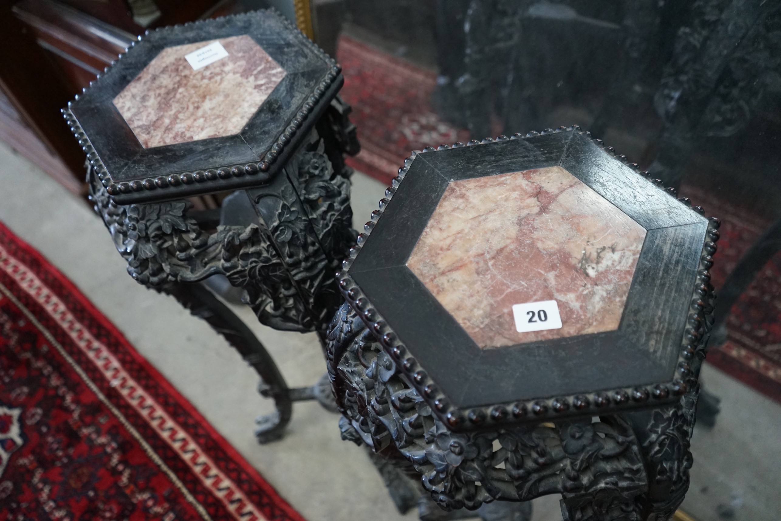 A pair of Chinese carved hardwood hexagonal marble topped vase stands, height 91cm